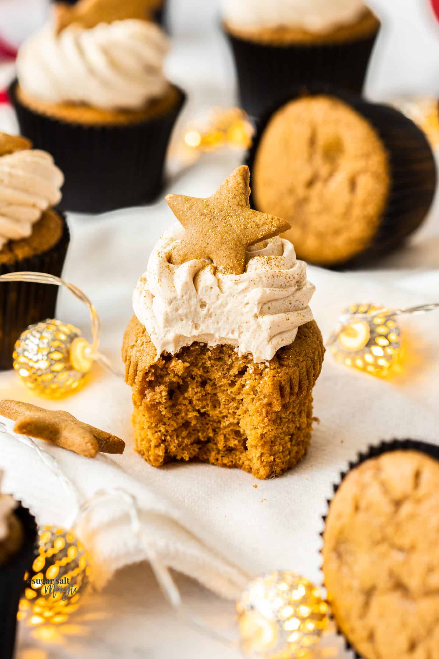 A gingerbread cupcake with a bite taken out showing the inside.