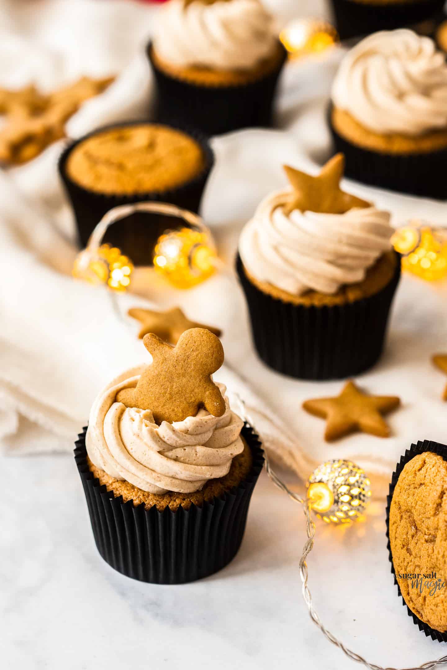 A gingerbread cupcake with a man shaped gingerbread cookie on top.