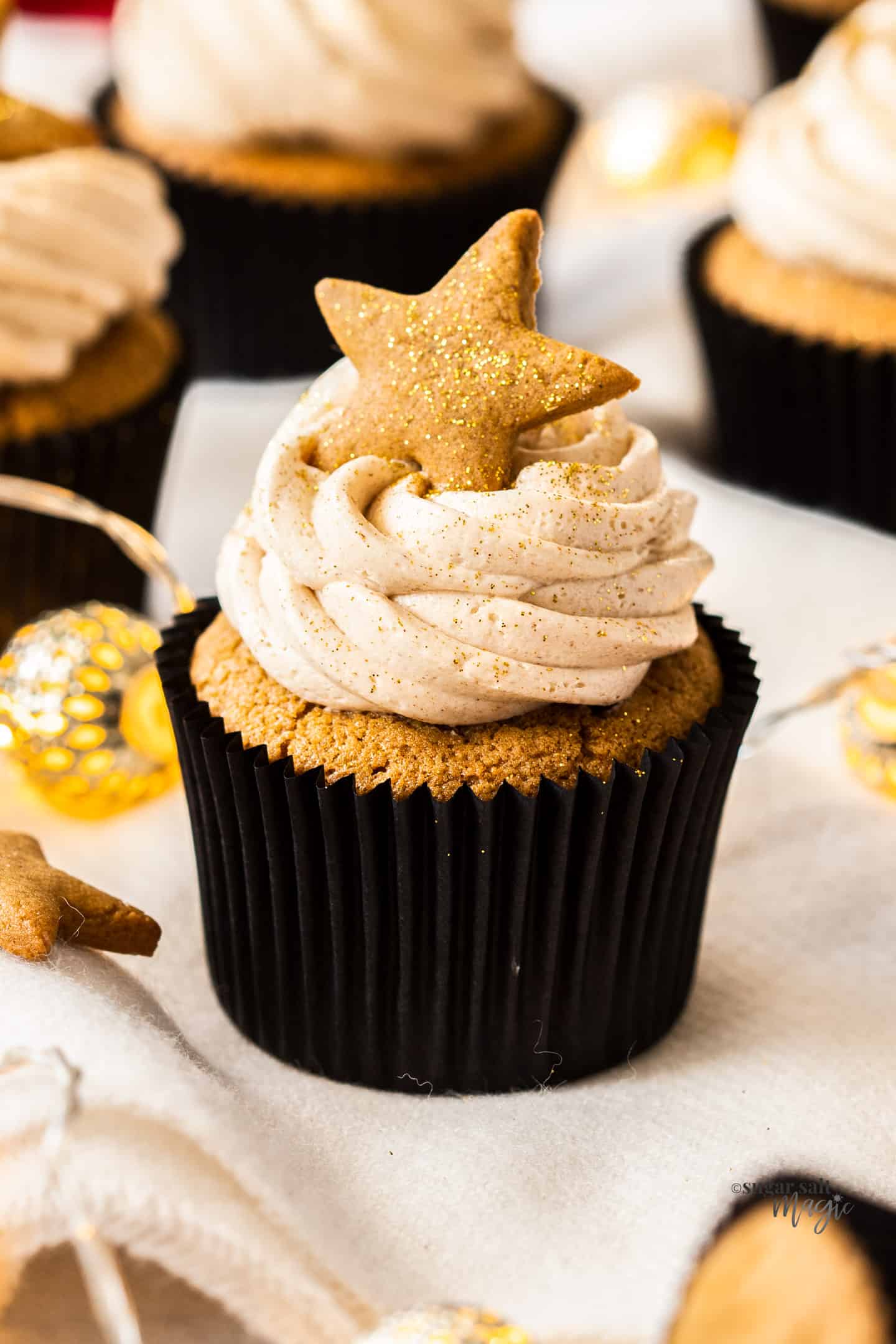 A gingerbread cupcake with a star shaped gingerbread cookie on top.