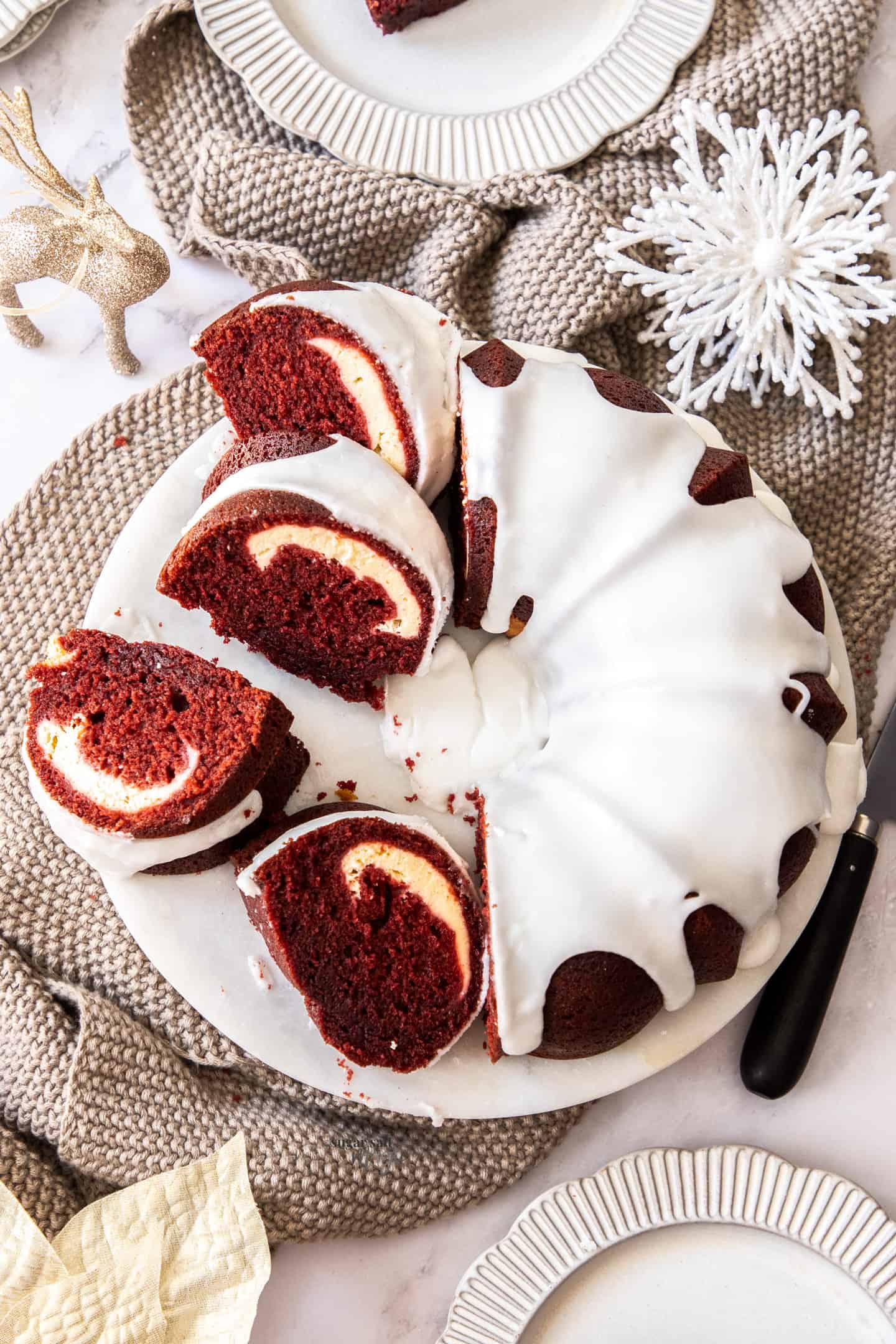 Top down view of a red velvet bundt cake on a white platter.