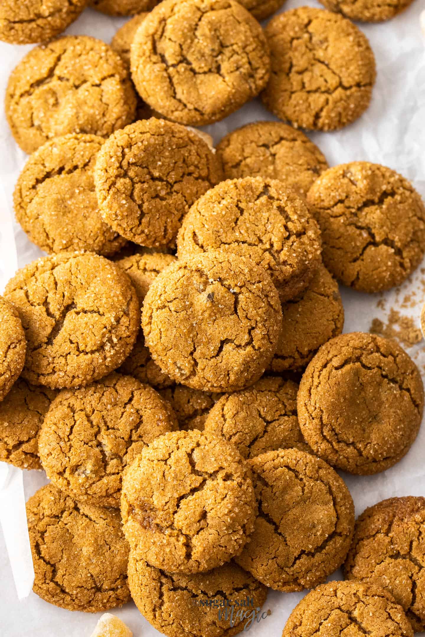 A pile of ginger cookies on a sheet of baking paper.