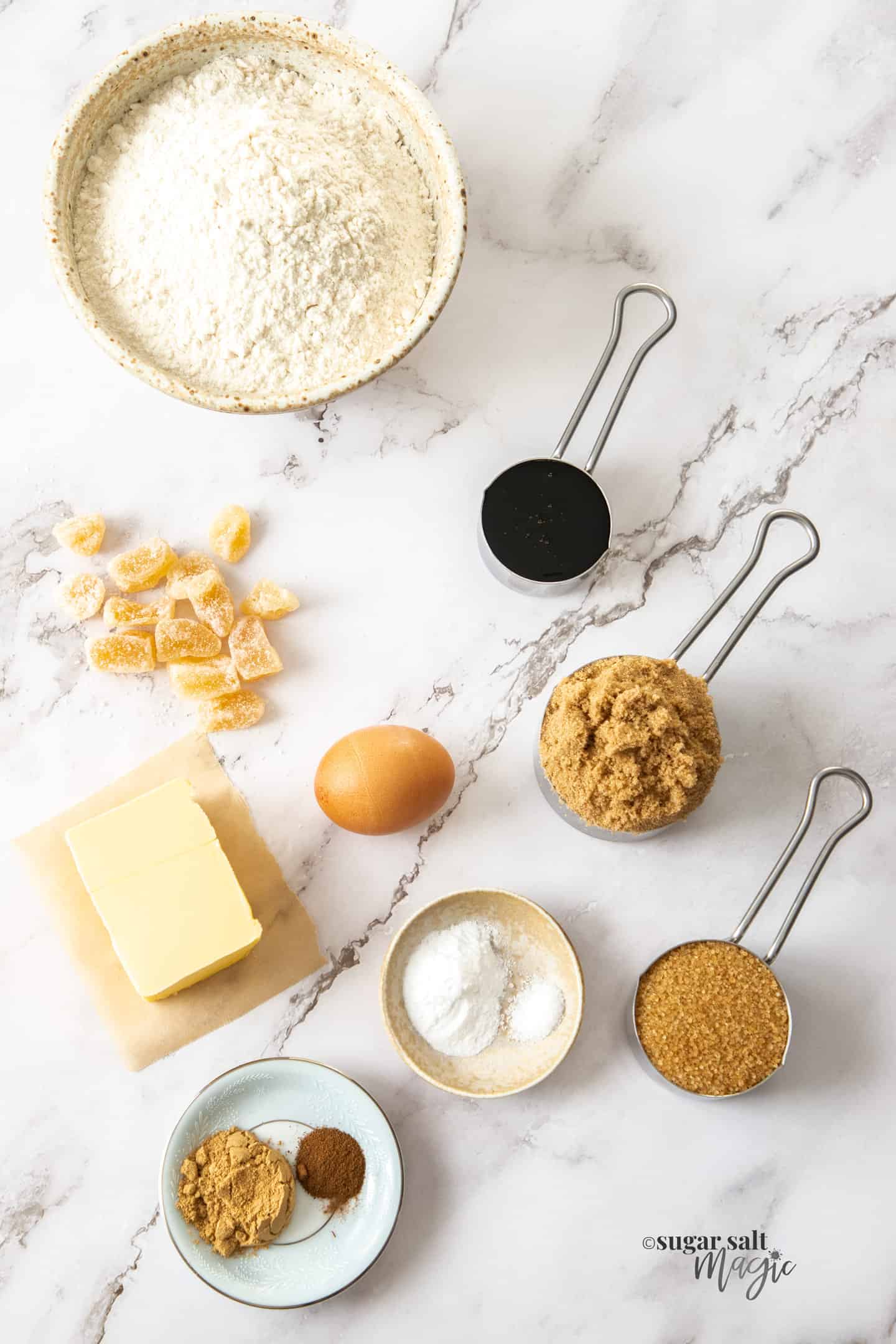 Ingredients for soft ginger cookies on a marble benchtop.