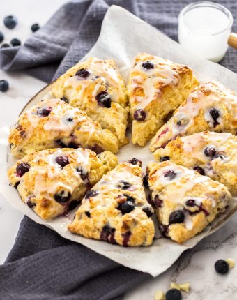 8 triangular blueberry scones on a serving plate.