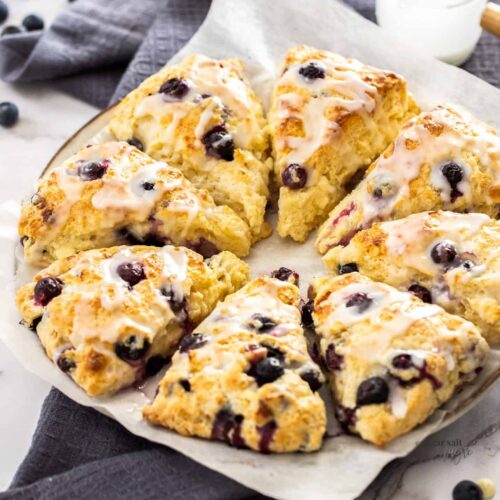 8 triangular blueberry scones on a serving plate.