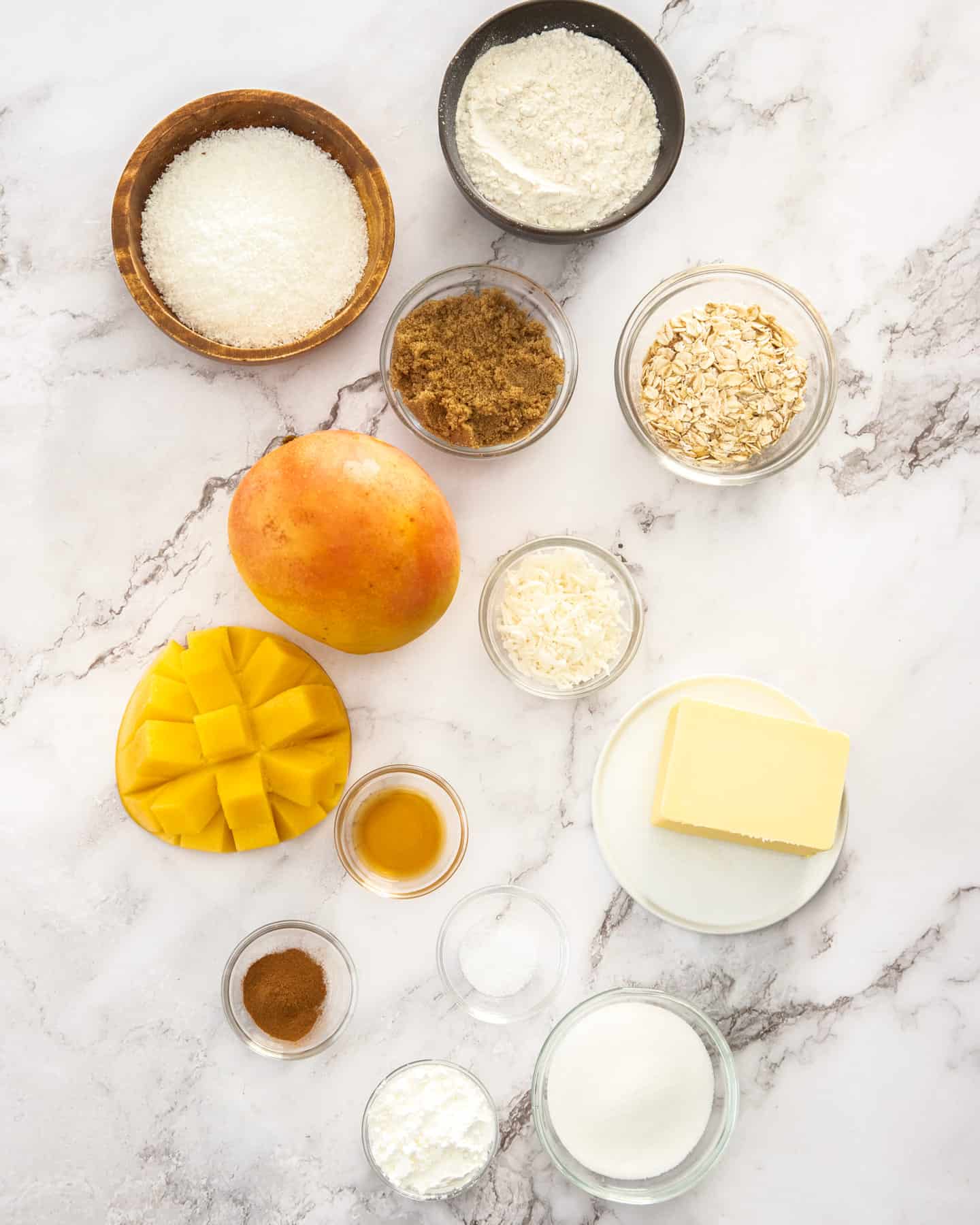 Ingredients for mango crumble on a marble bench top