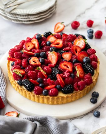 A tart filled with custard and topped with fresh berries.
