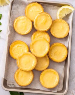 A gold tray filled with lemon tartlets.
