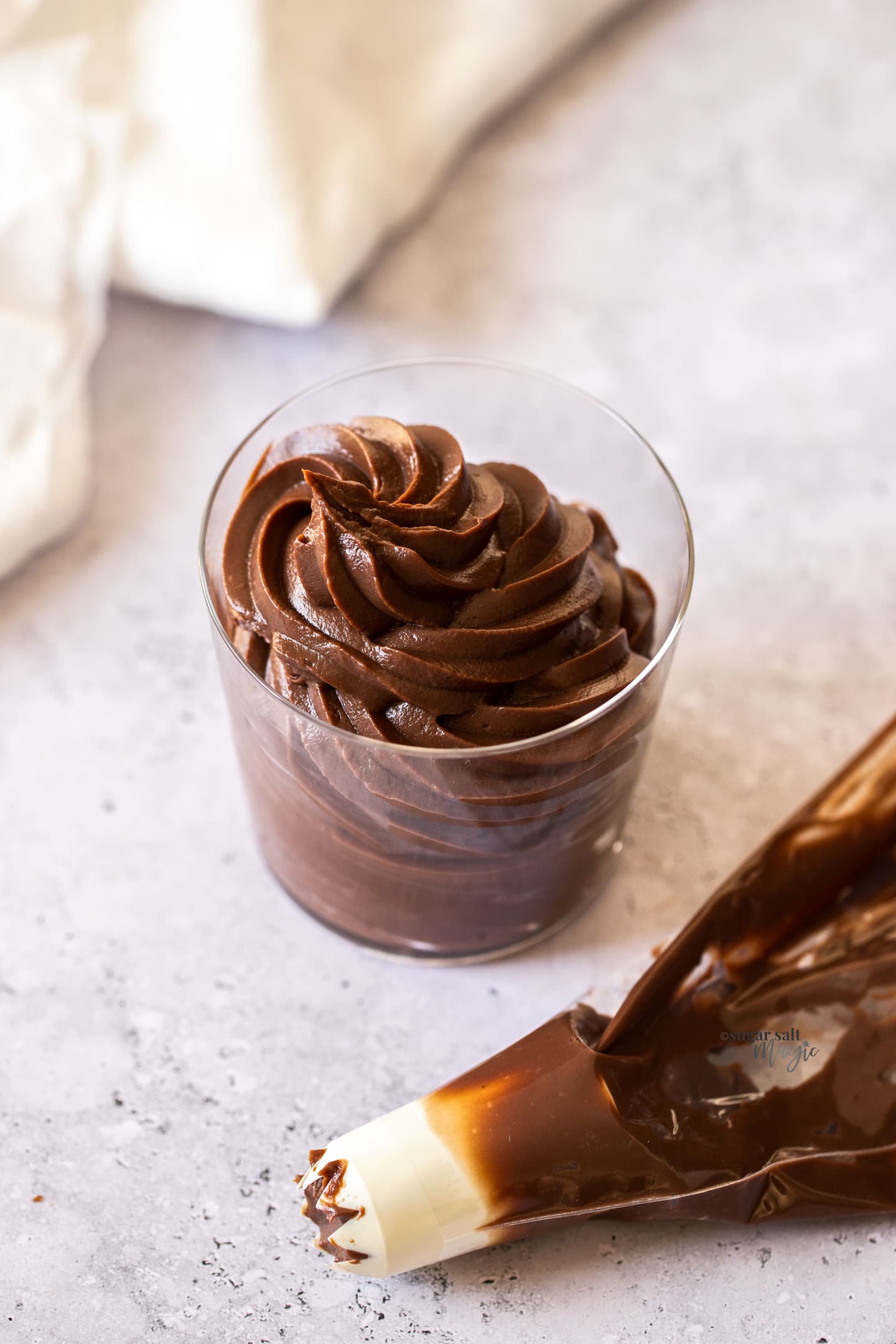 Chocolate pastry cream piped into a glass.