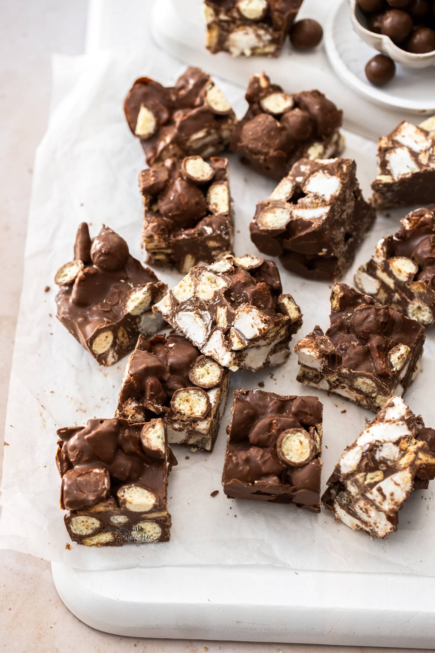 Squares of rocky road on a sheet of baking paper.