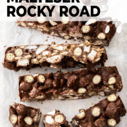 Big slices of Malteser rocky road on a white wooden platter.