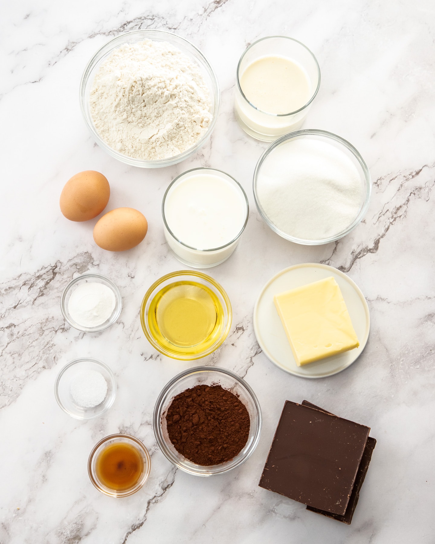 Ingredients for marble loaf cake on a marble surface.