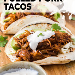 Closeup of a taco filled with BBQ pulled pork, topped with sour cream.