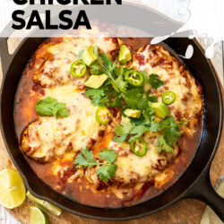 Top down view of a cast iron skillet filled with cheese topped chicken in salsa.