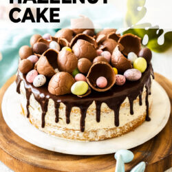 A cake topped with loads of Easter eggs on a marble platter.