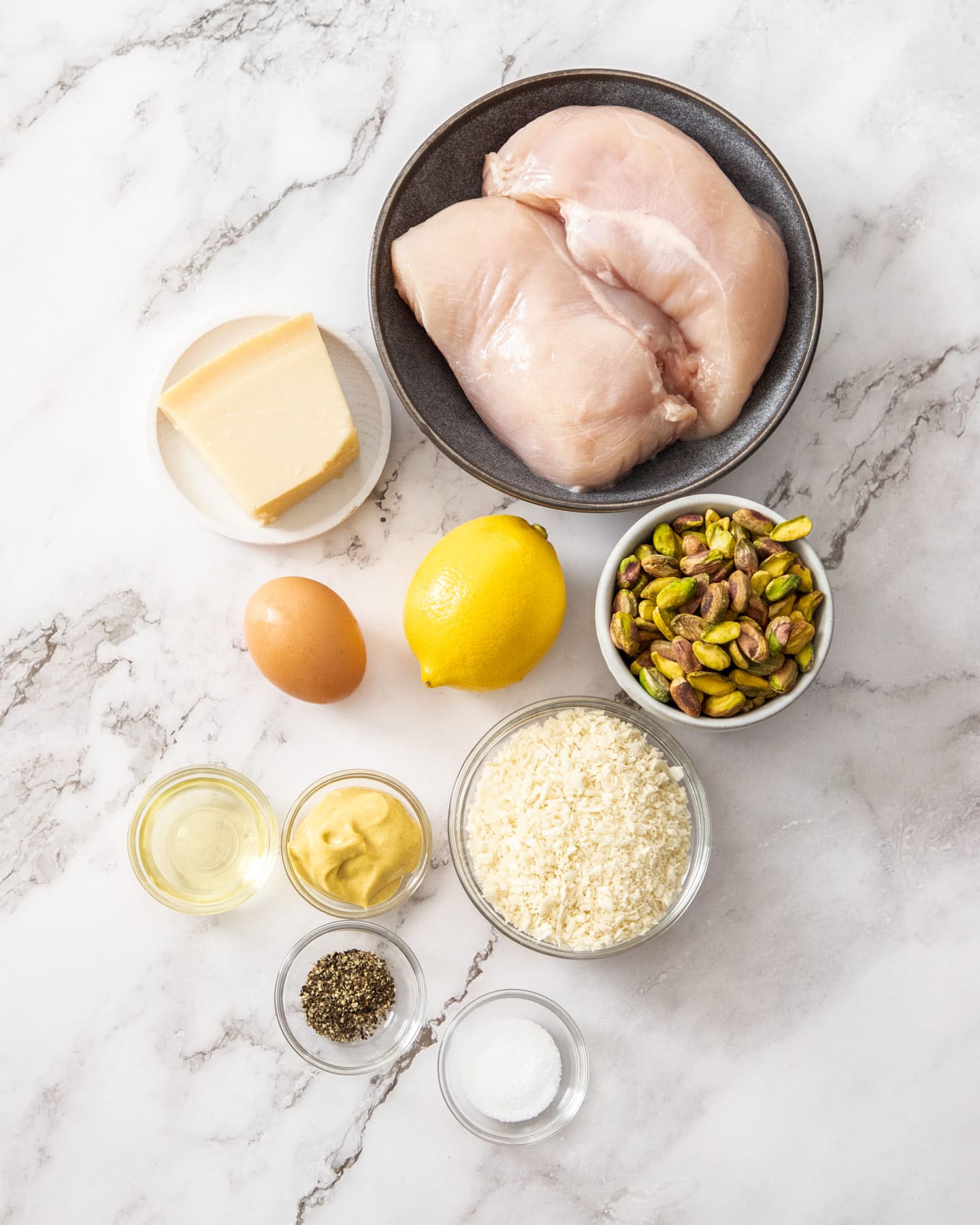 Ingredients for pistachio chicken on a marble work top.