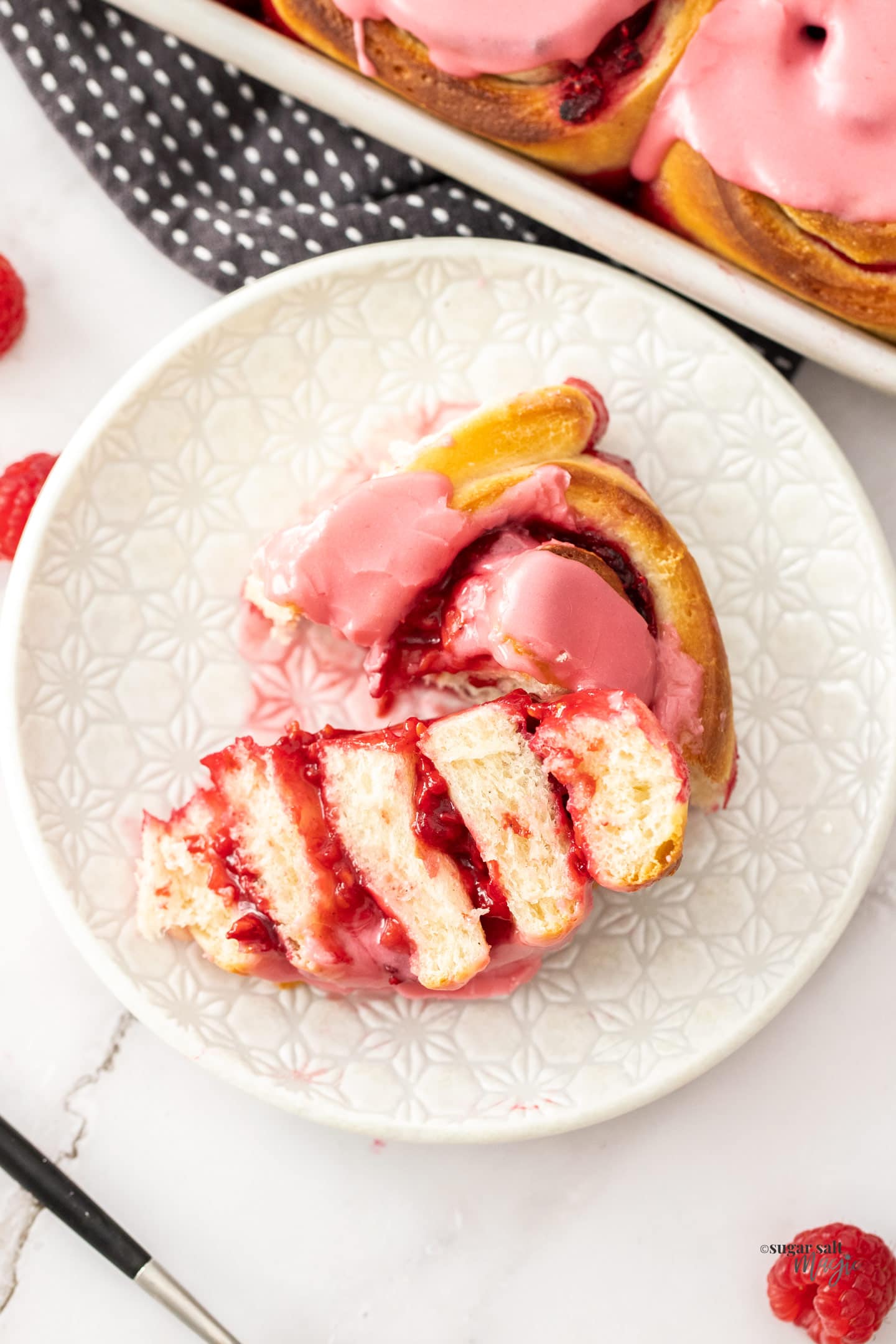 A raspberry sweet roll that's been cut open to show the inside.