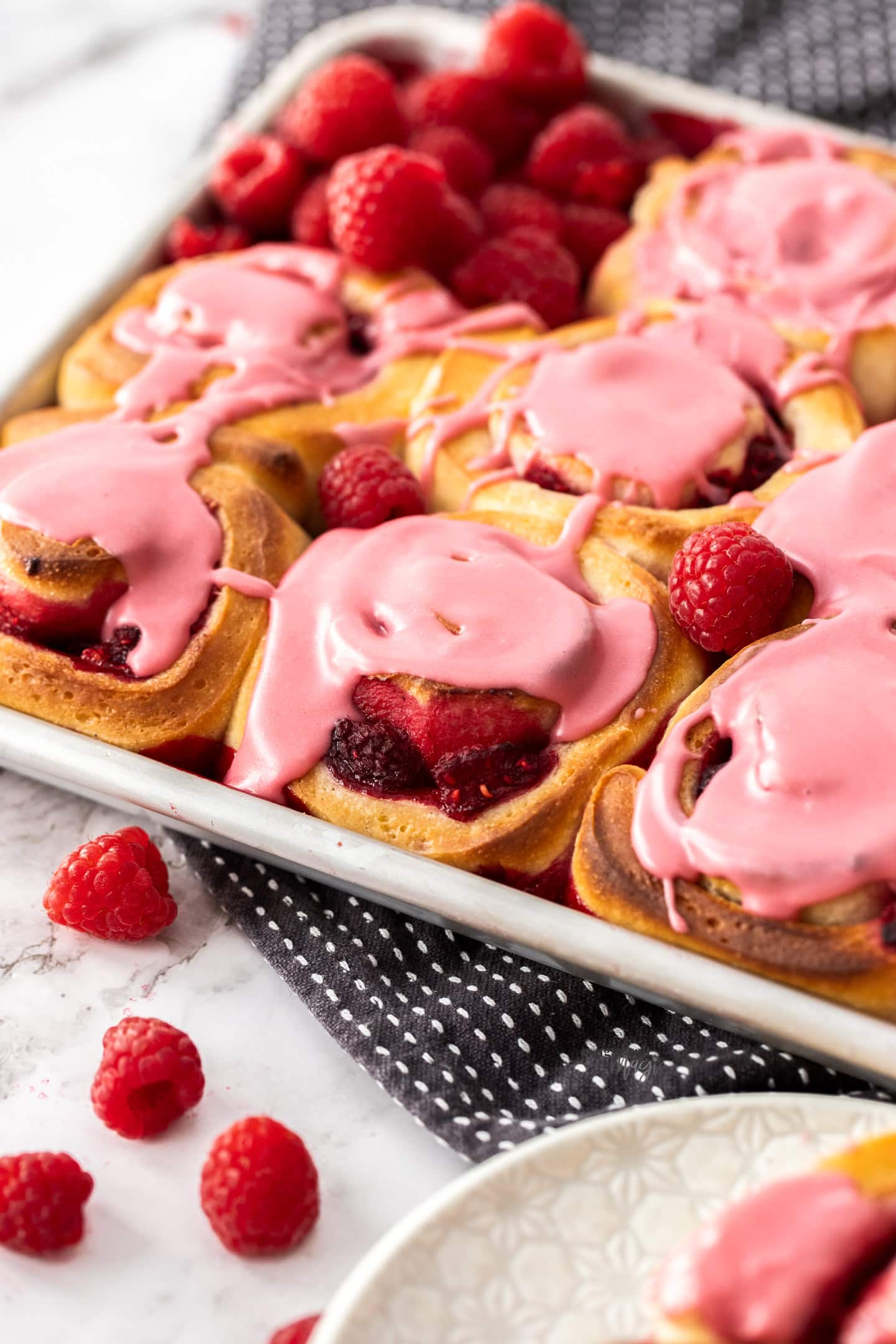 Closeup of raspberry sweet rolls in a baking tin.