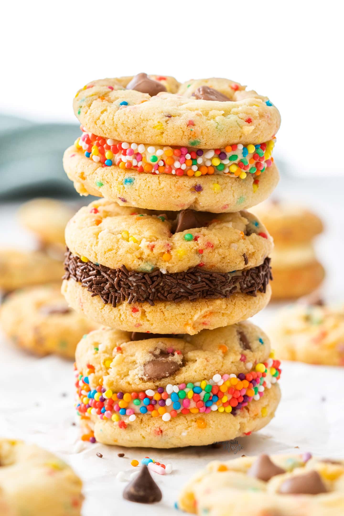 A stack of 3 buttercream-filled birthday cake cookies.