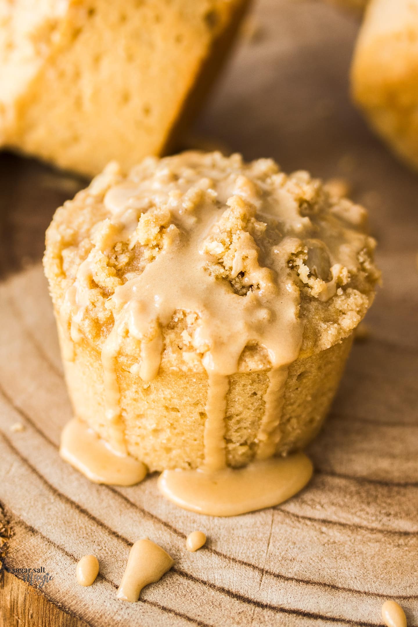 Closeup of a coffee muffin with coffee glaze dribbling down the side.