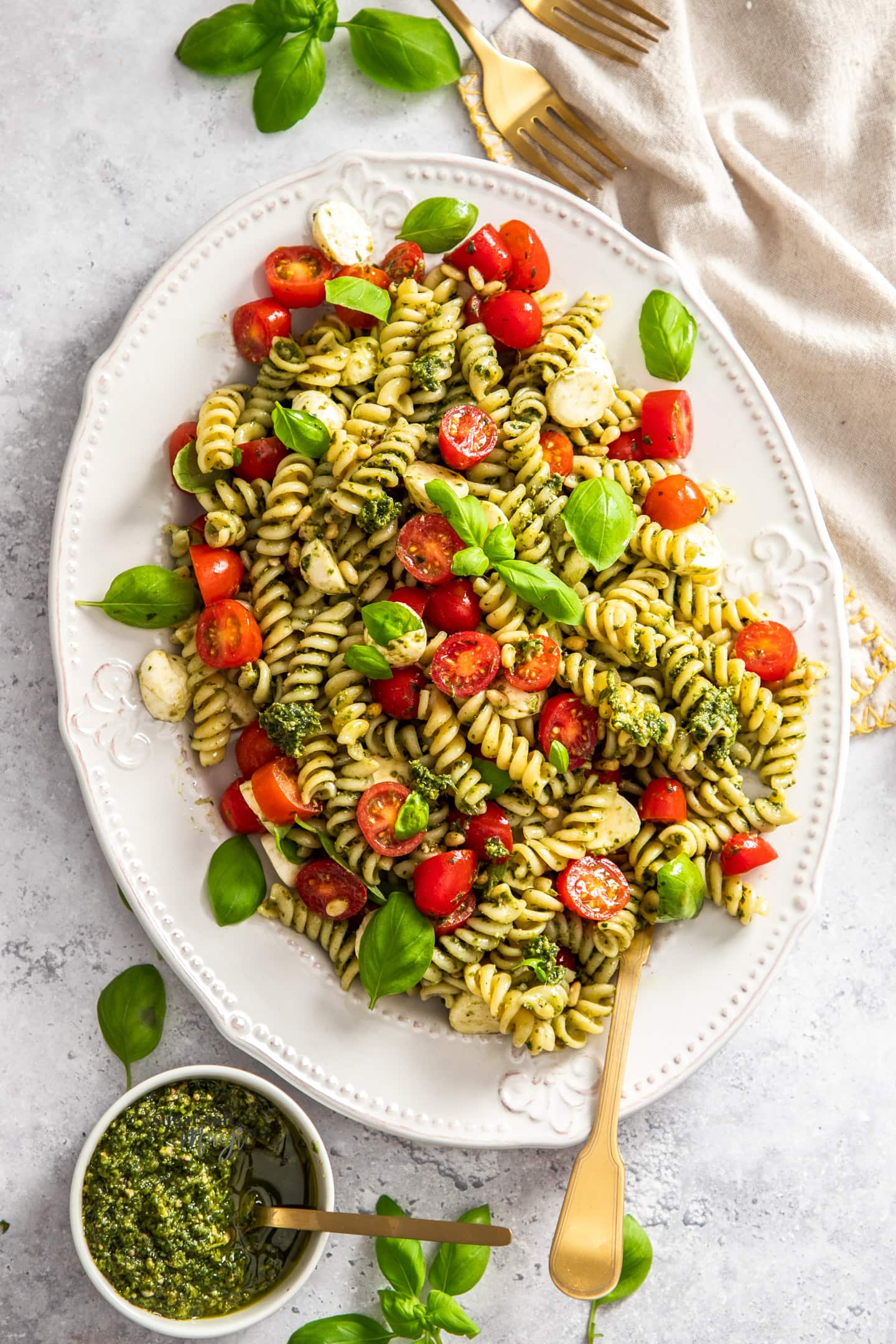 Top down view of a plate of pesto caprese pasta salad.