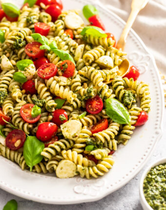 Closeup of pesto caprese pasta salad on a large platter.