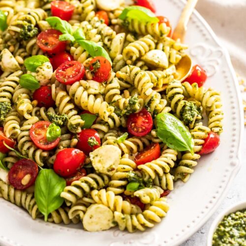 Closeup of pesto caprese pasta salad on a large platter.