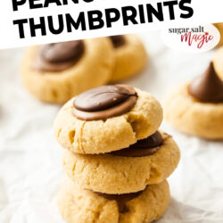 A stack of 3 thumbprint cookies topped with chocolate.