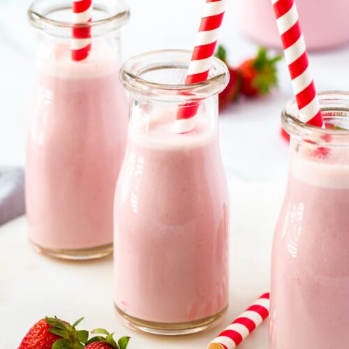 Closeup of a mini milk bottle filled with strawberry milk.