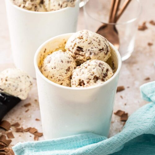 2 ice cream tubs filled with scoops of chocolate chip ice cream.
