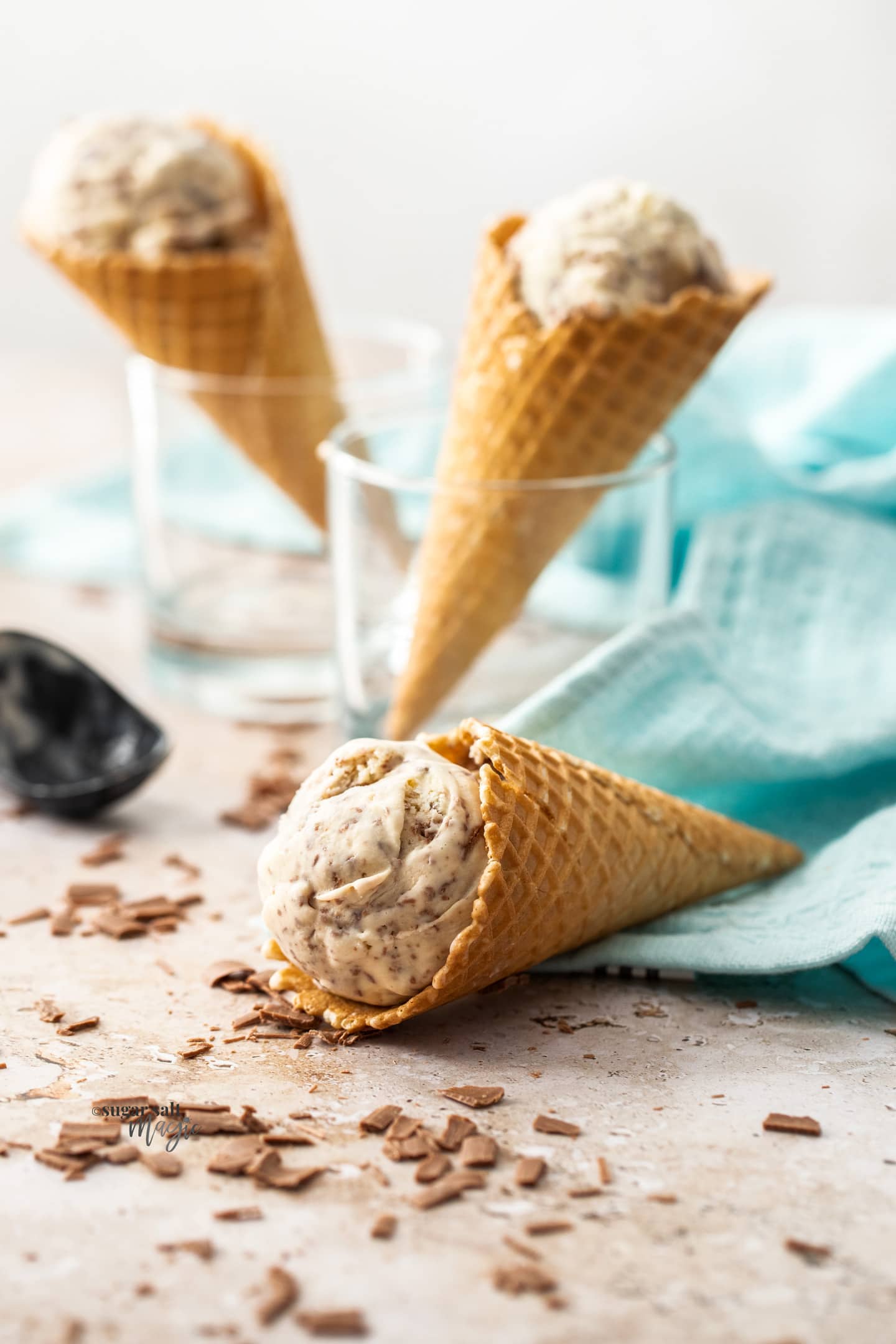 3 waffle cones with scoopes of chocolate chip ice cream.
