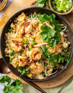 Top down view of a bowl of prawn fried rice topped with coriander.