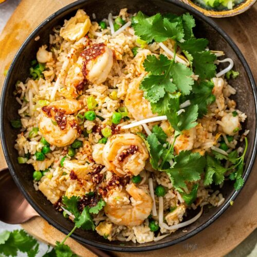 Top down view of a bowl of prawn fried rice topped with coriander.