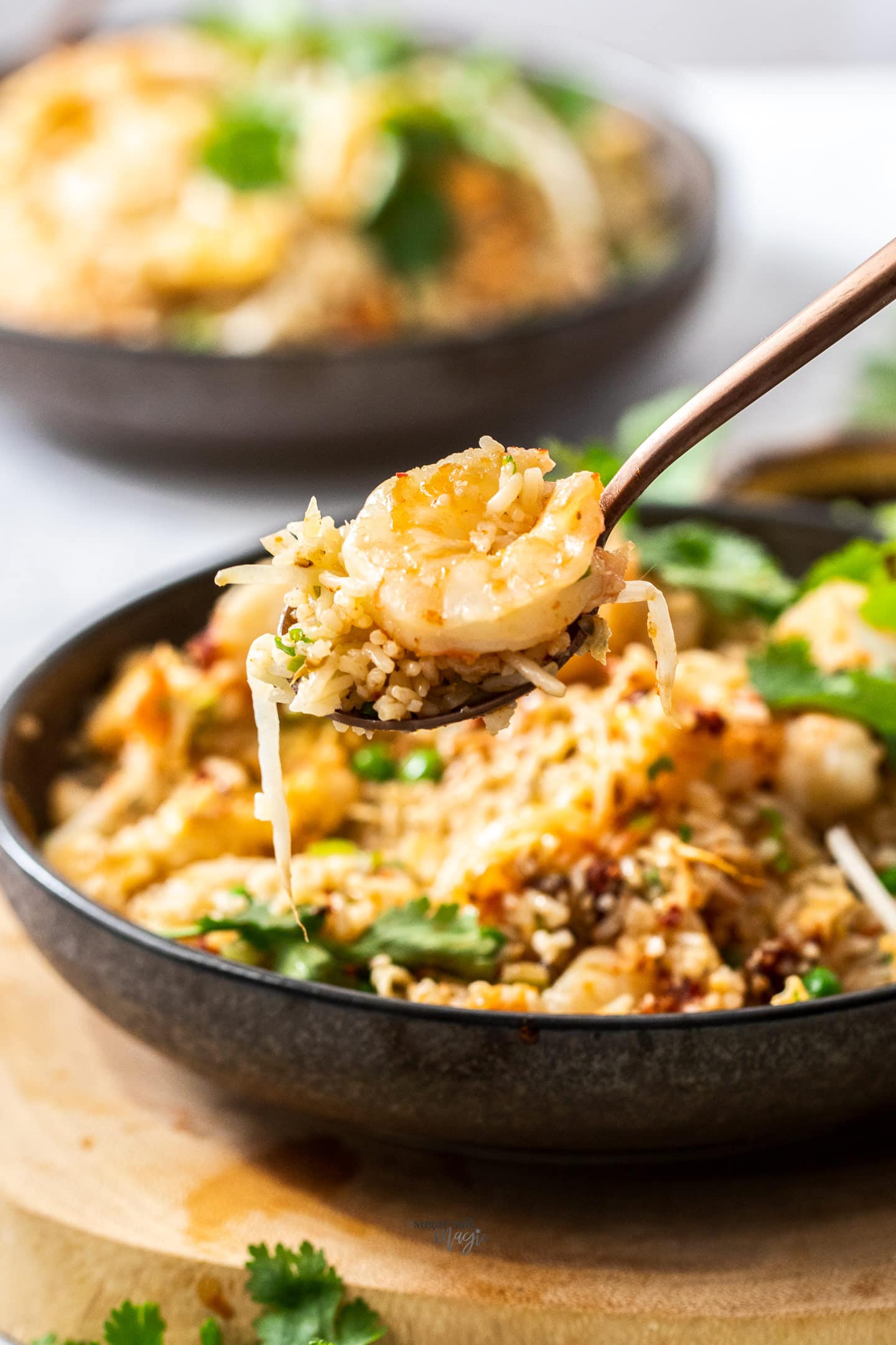 A spoon topped with prawn fried rice.