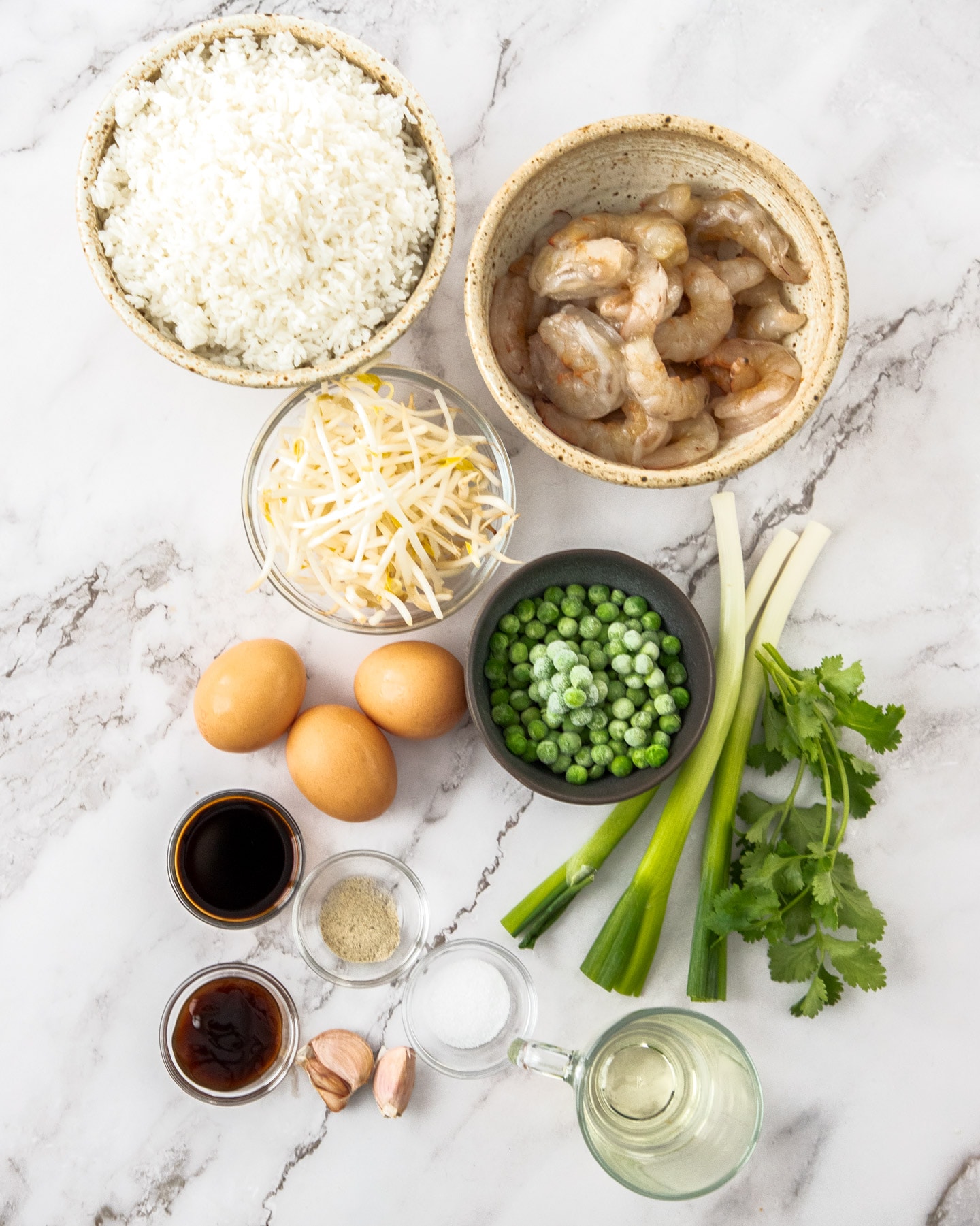 Ingredients for prawn fried rice on a marble background.