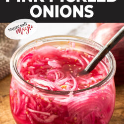 A glass jar filled with pink pickled onions.