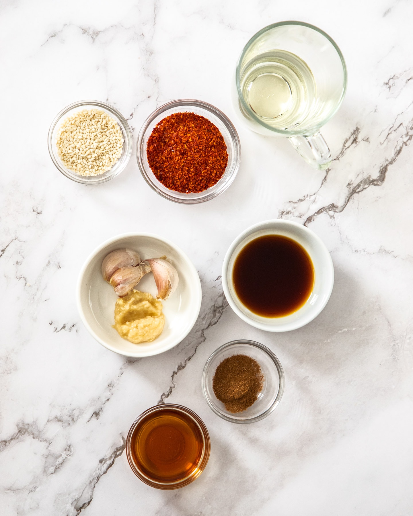Ingredients for sesame chilli oil on a marble surface.