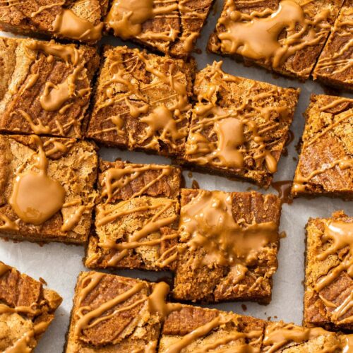 Top down view of a batch of Biscoff blondies, dolloped with Biscoff spread.