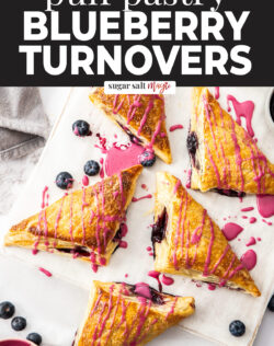 5 blueberry turnovers on a wooden board.