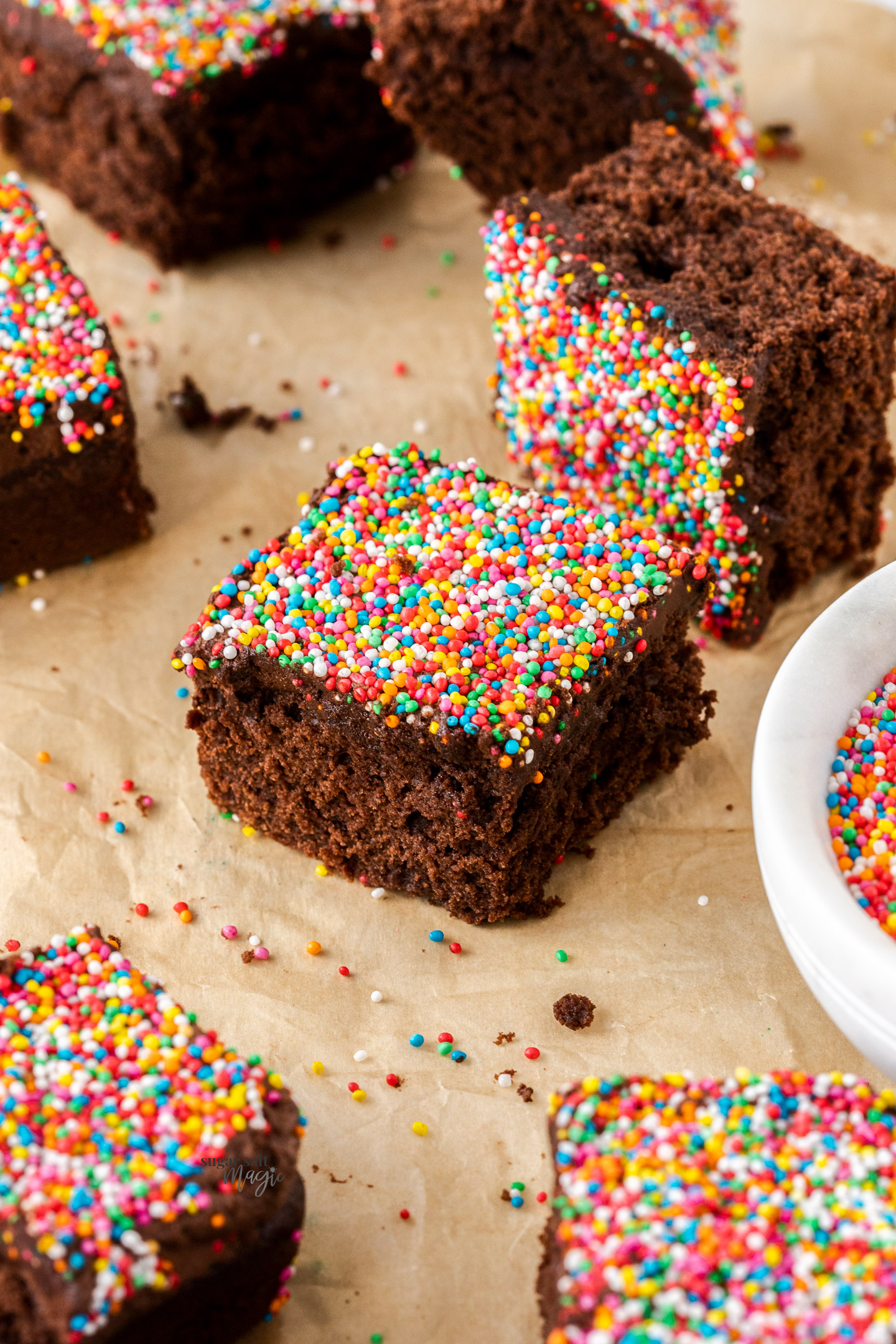 Squares of chocolate cake, covered in sprinkles.