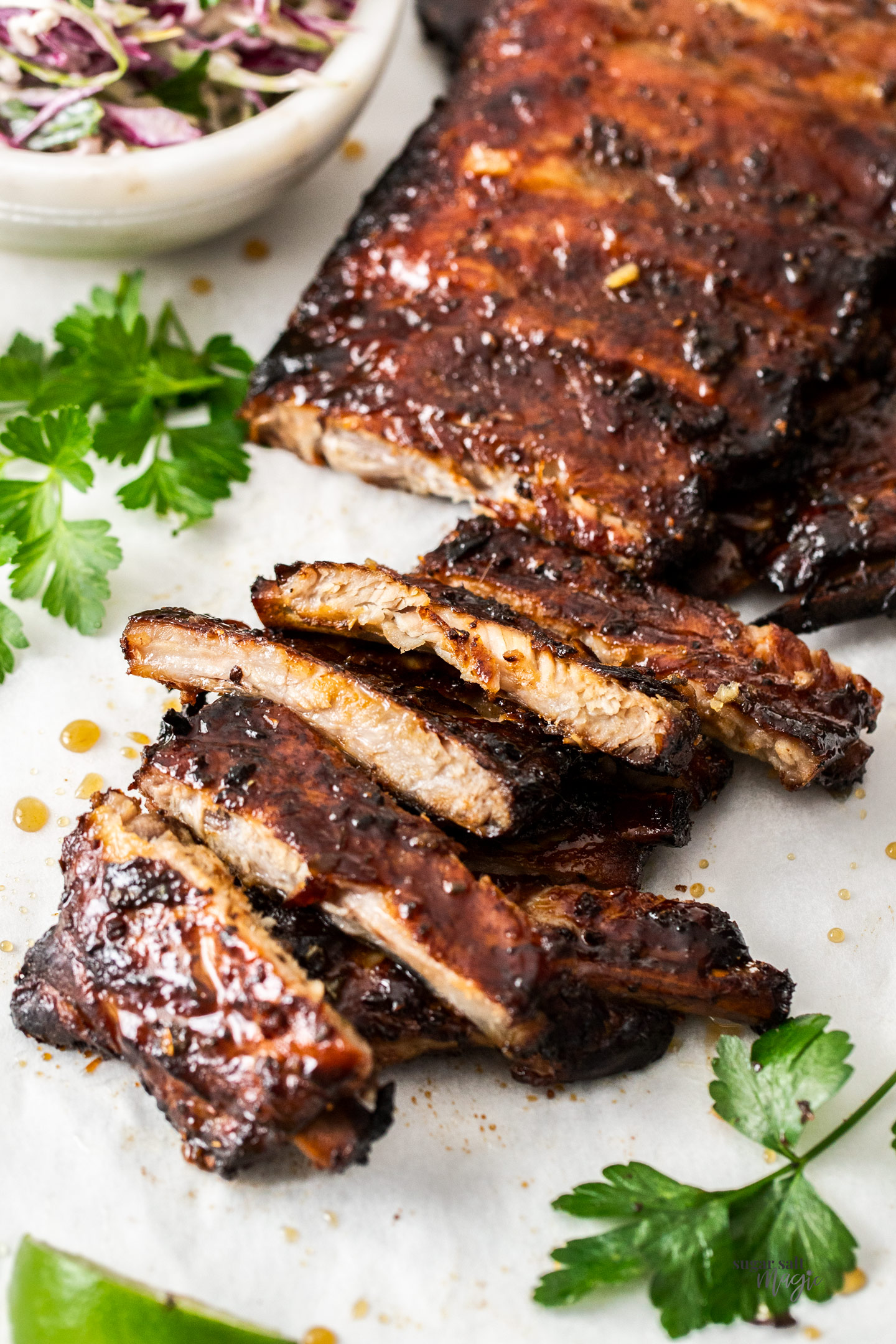 Cooked glazed pork ribs on a baking tray.