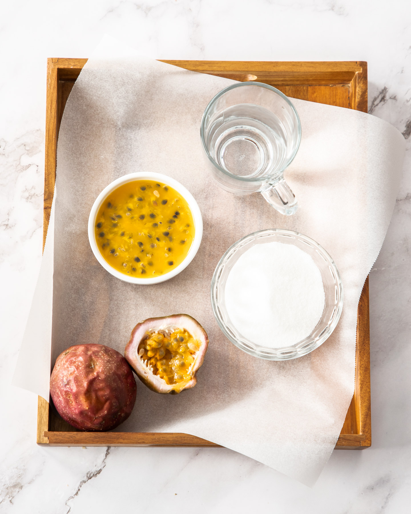 Ingredients for passionfruit syrup on a wooden tray.