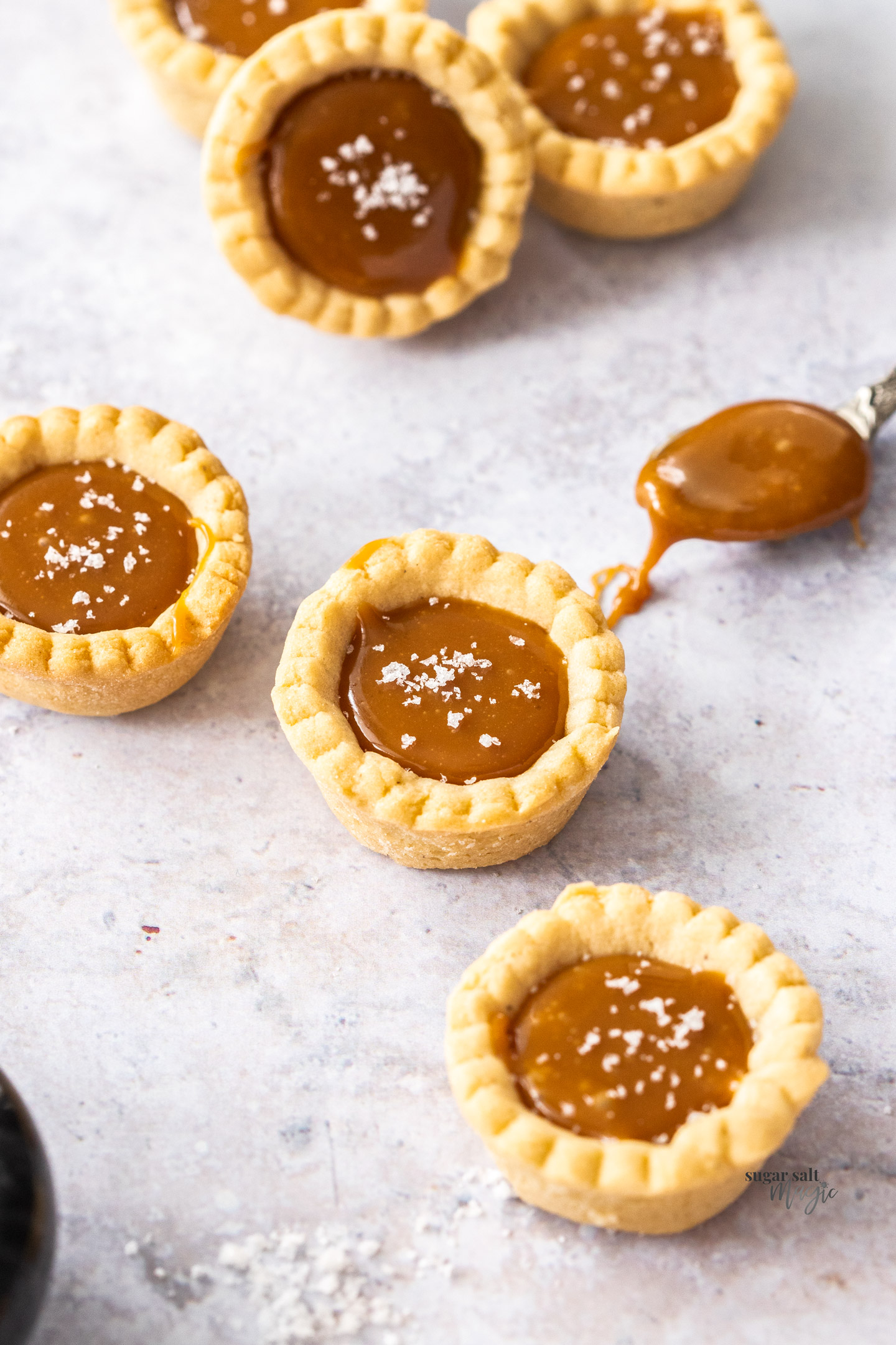 Top down view of a batch of salted caramel tartlets.
