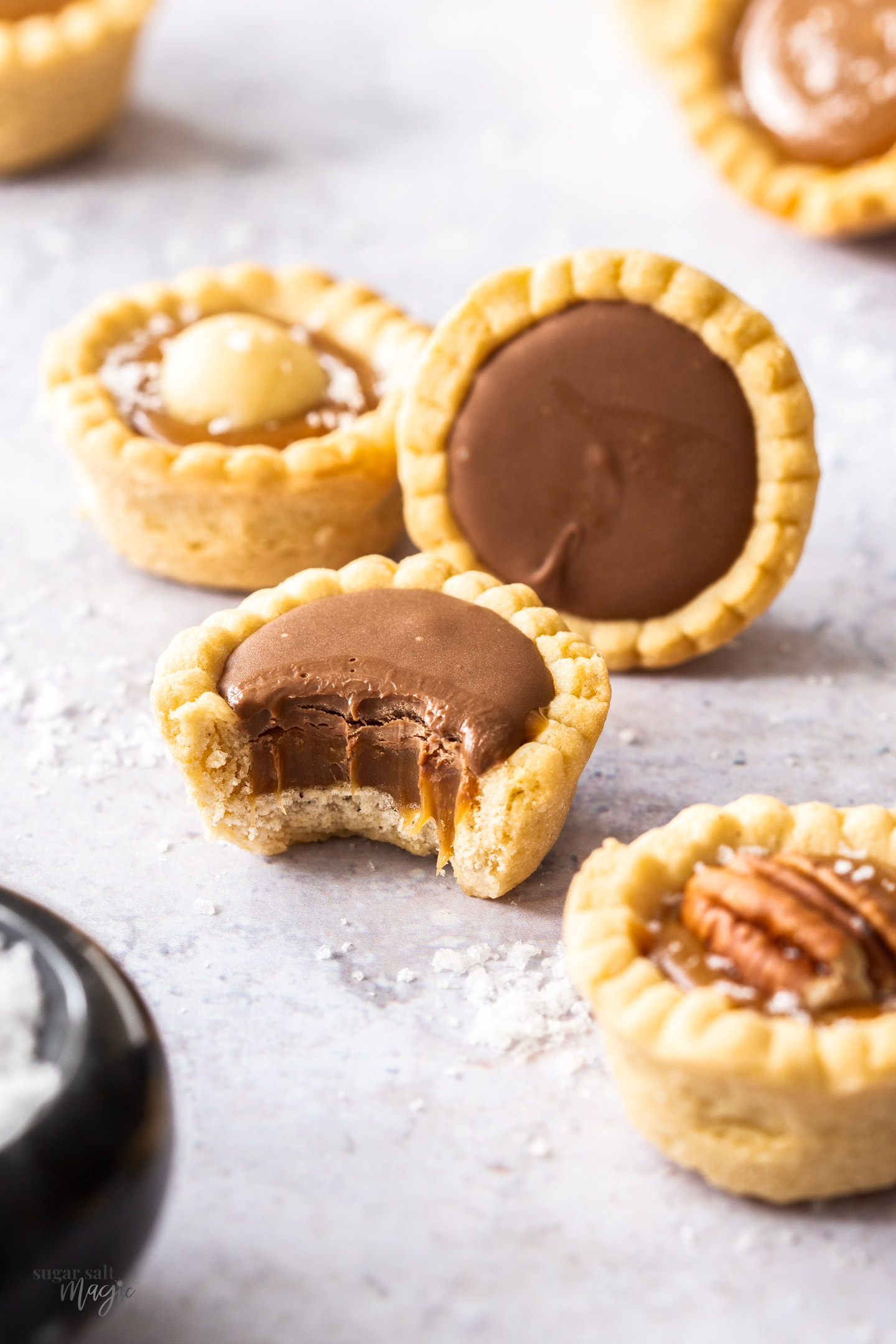 Salted caramel tartlets topped with chocolate and nuts.