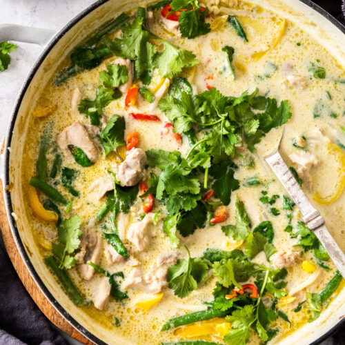 A large skillet filled with green chicken curry.