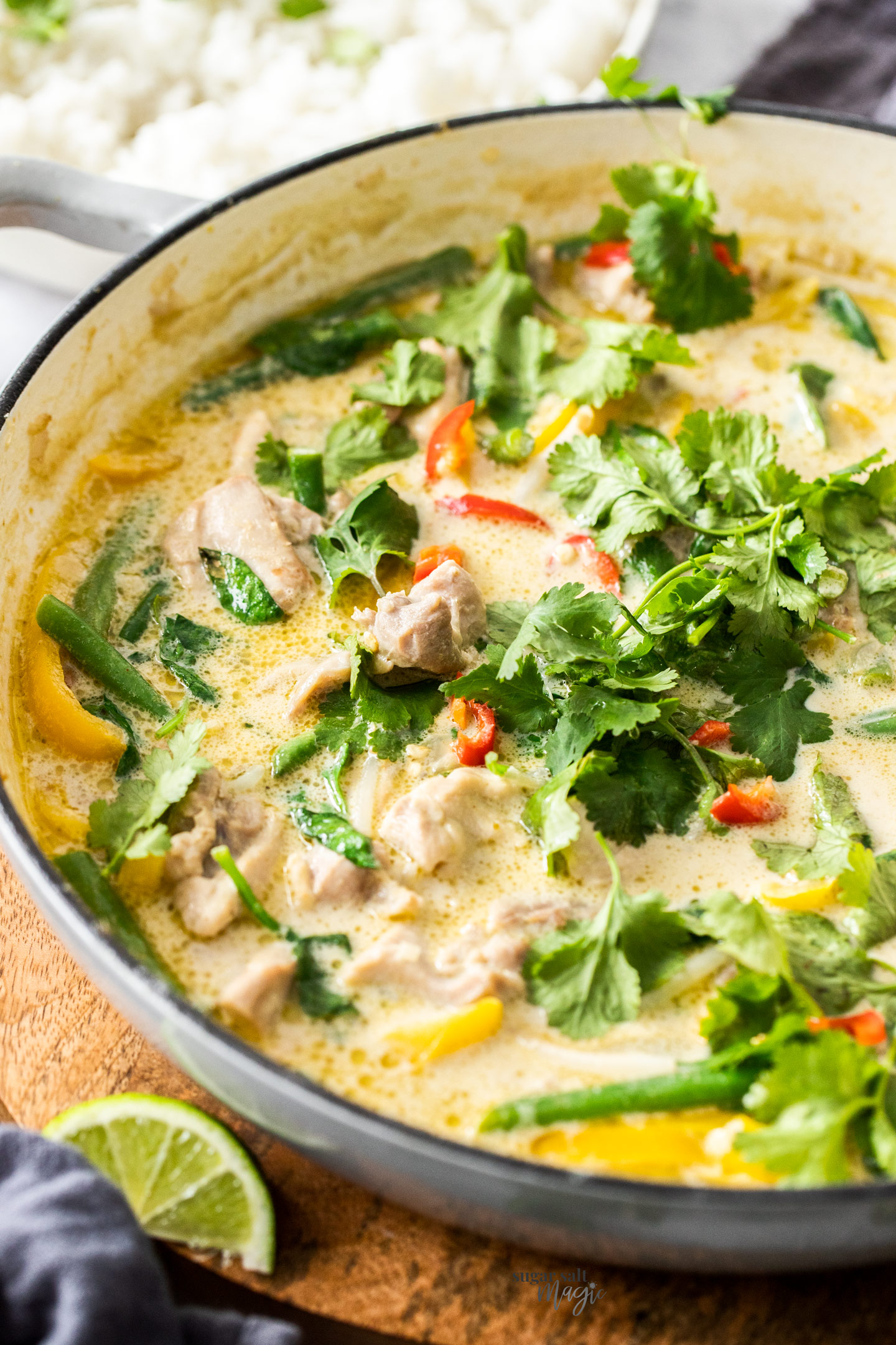 Green chicken curry in a pan topped with coriander.