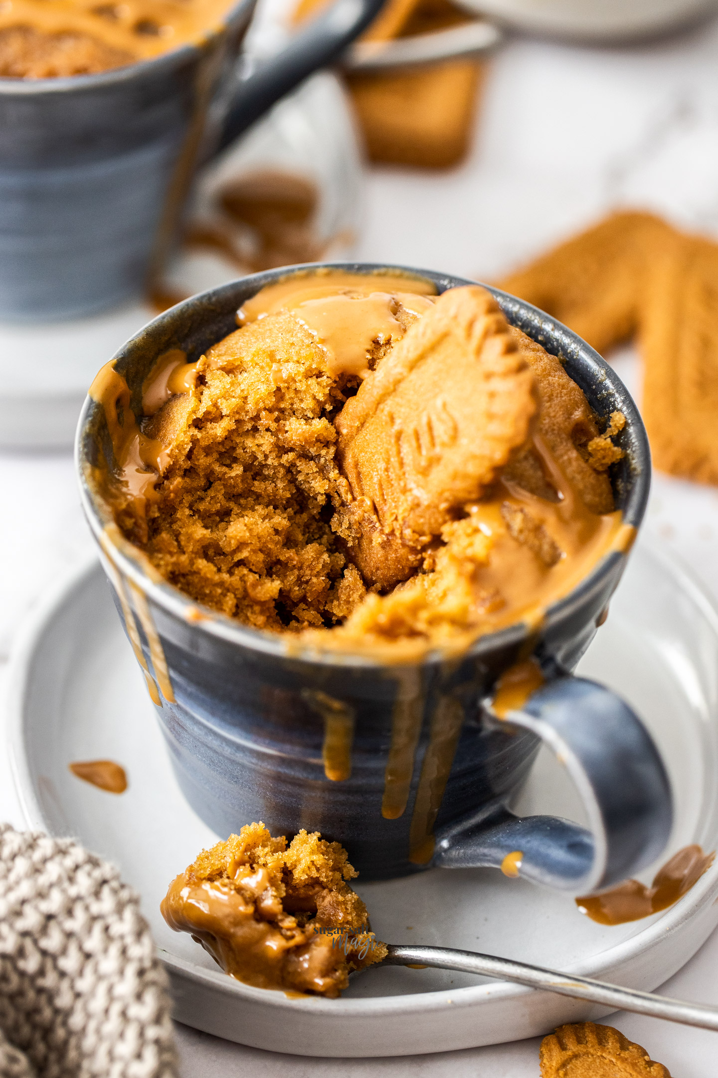 Closeup of a Biscoff mug cake with a Biscoff cookie in the top.