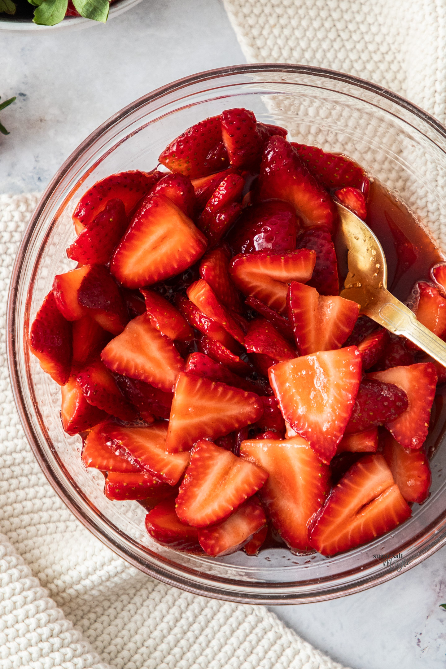 Closeup of macerated strawberries in a bowl.