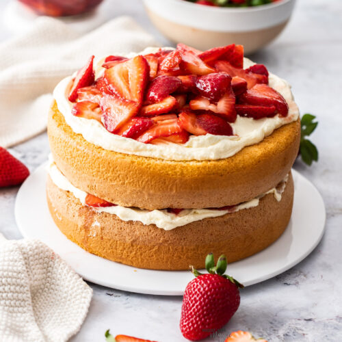 A strawberry sponge cake on a cake platter.