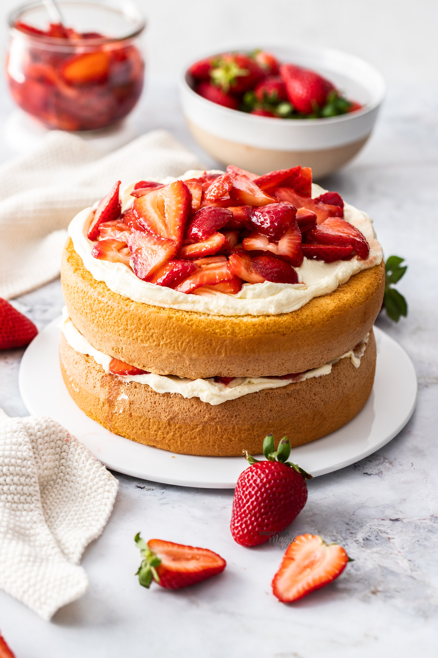 A strawberry sponge cake on a cake platter.