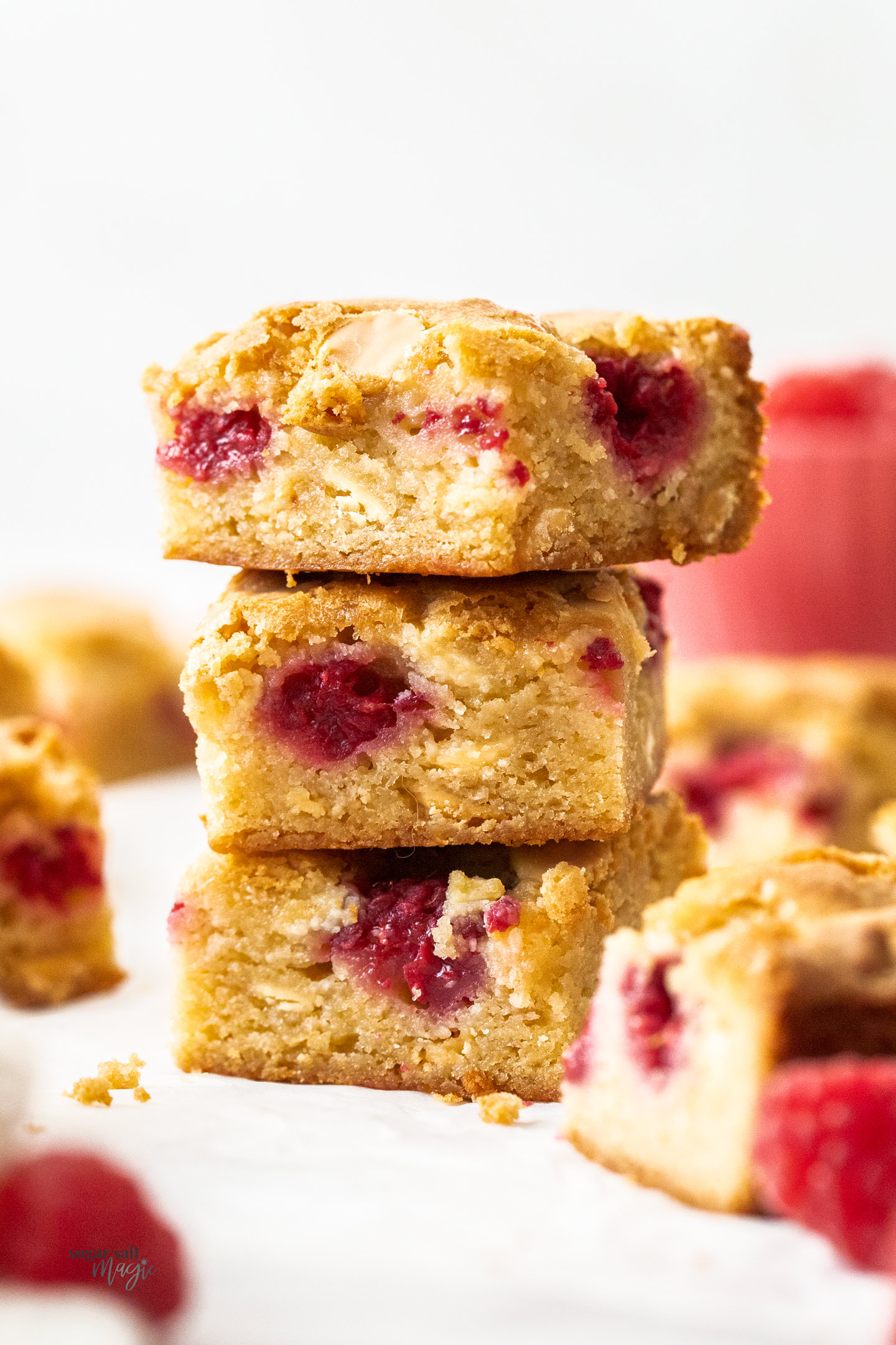 A stack of 3 blondies filled with raspberries.
